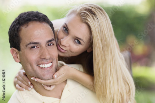 Hispanic woman kissing boyfriend's cheek