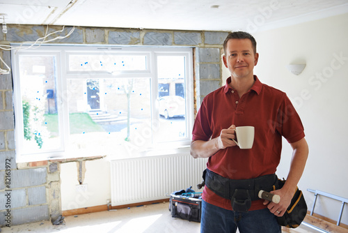 Photos Builder Carrying Out Home Improvements Taking A Break