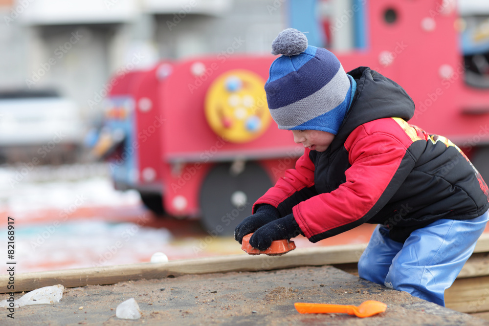 Child playing with toy in the sandbox Child playing with toy in the sandbox