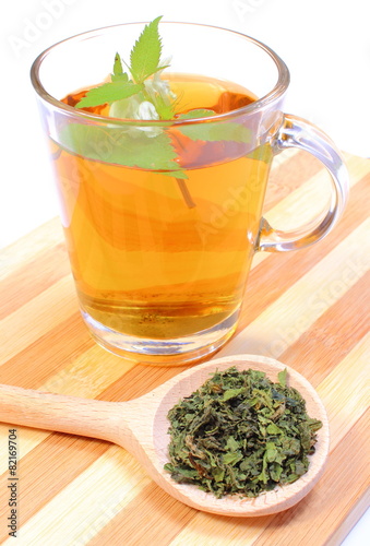 Fresh and dried nettle with cup of beverage
