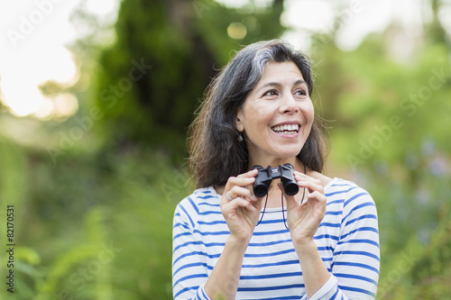 Wallpaper Mural Hispanic woman using binoculars outdoors Torontodigital.ca