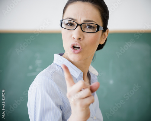 Caucasian teacher scolding in classroom