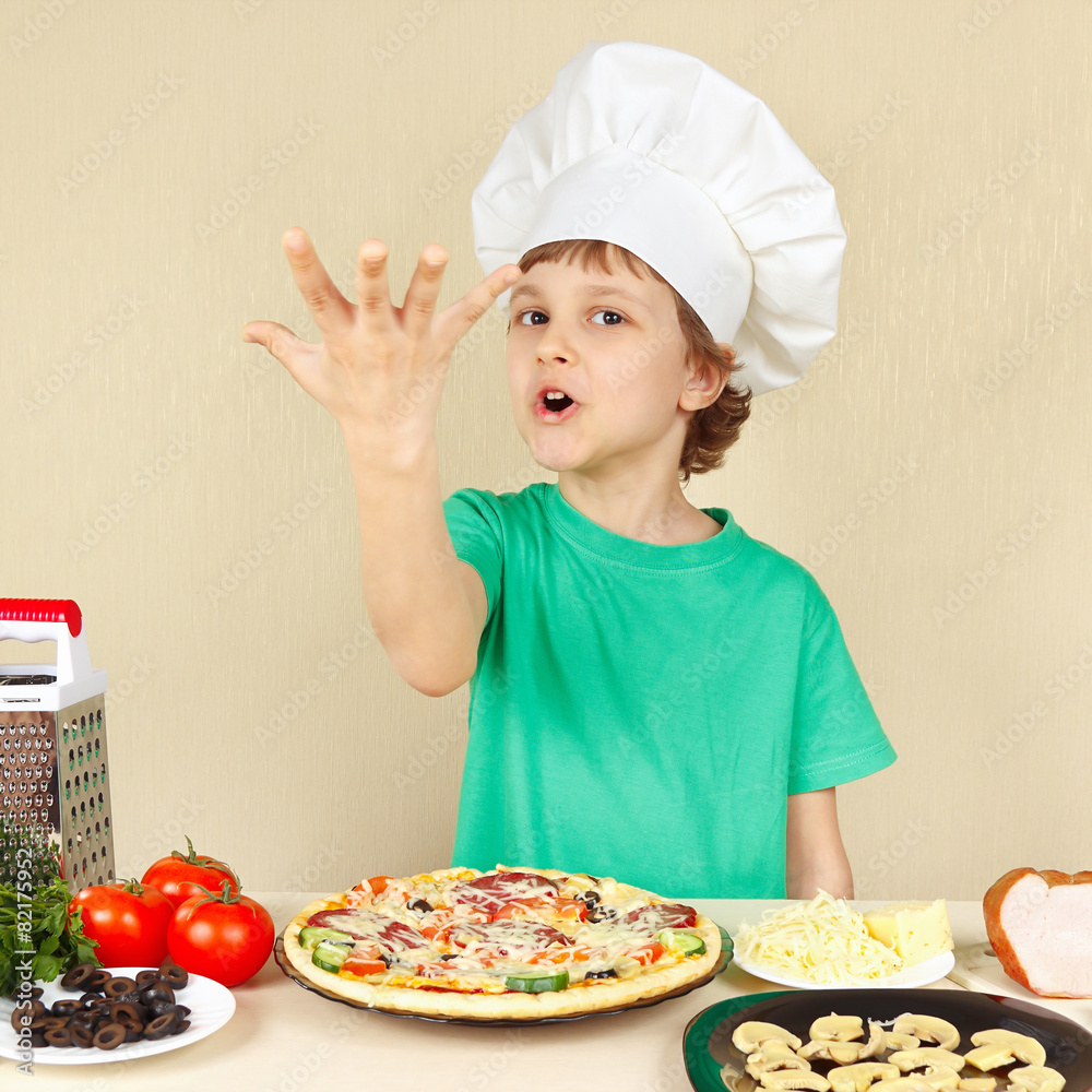 Little funny chef expressive enjoys a cooked pizza Little funny chef expressive enjoys a cooked pizza