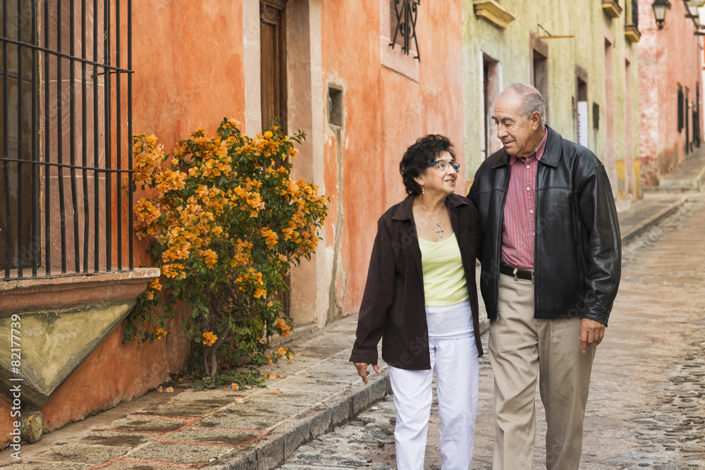 Older Hispanic couple walking on village street Older Hispanic couple walking on village street