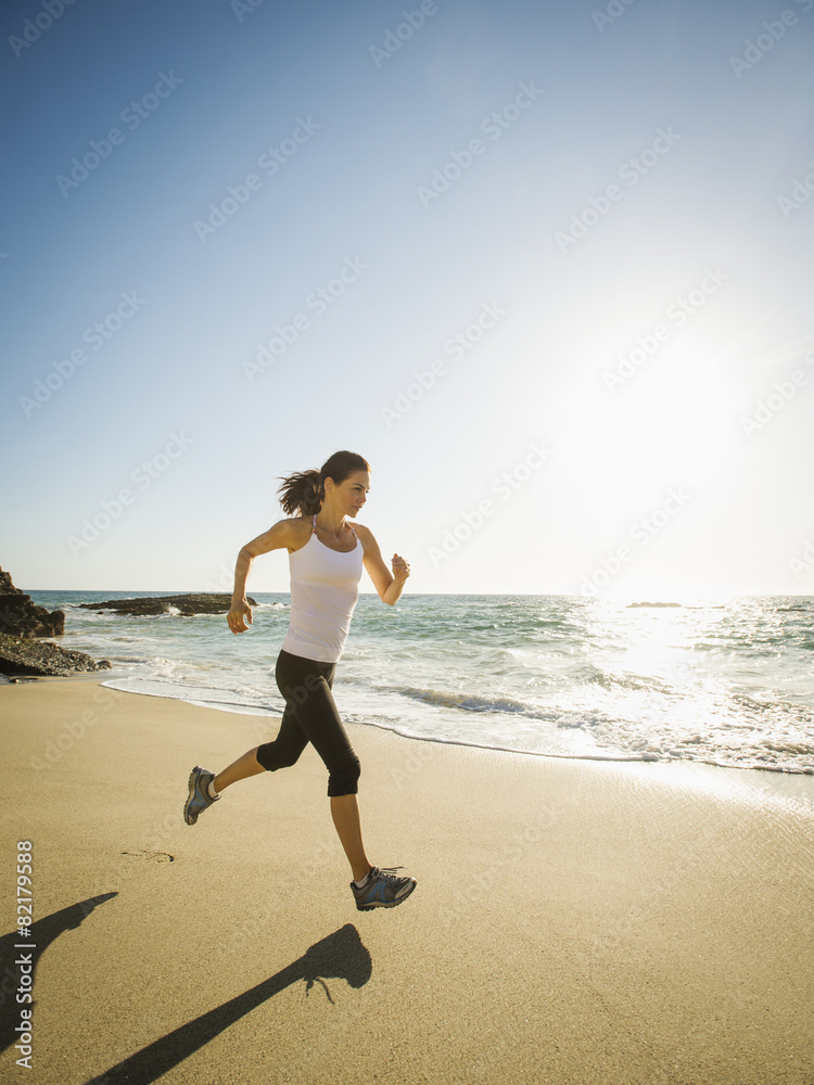 Mixed race woman running on beach Mixed race woman running on beach