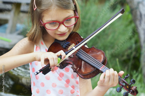 Hispanic girl playing violin outdoors
