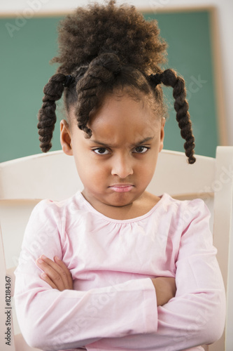 African American girl frowning in classroom