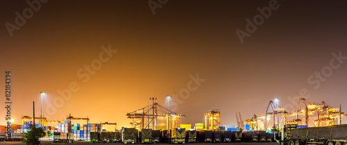cranes with cargoes containers and truck at industrial port