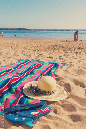towel and sunbathing accessories on sandy beach