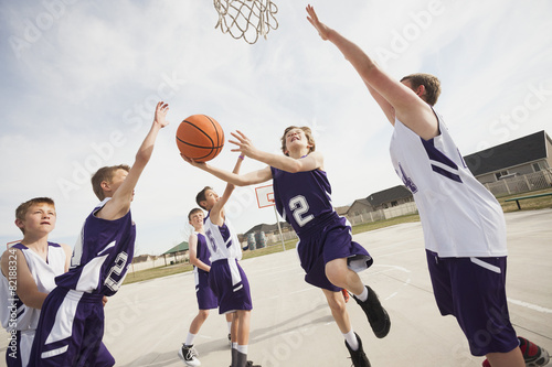 Caucasian boys playing basketball on court photo