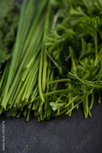 Spring garden fresh chives,parsley and dill on black slate  back