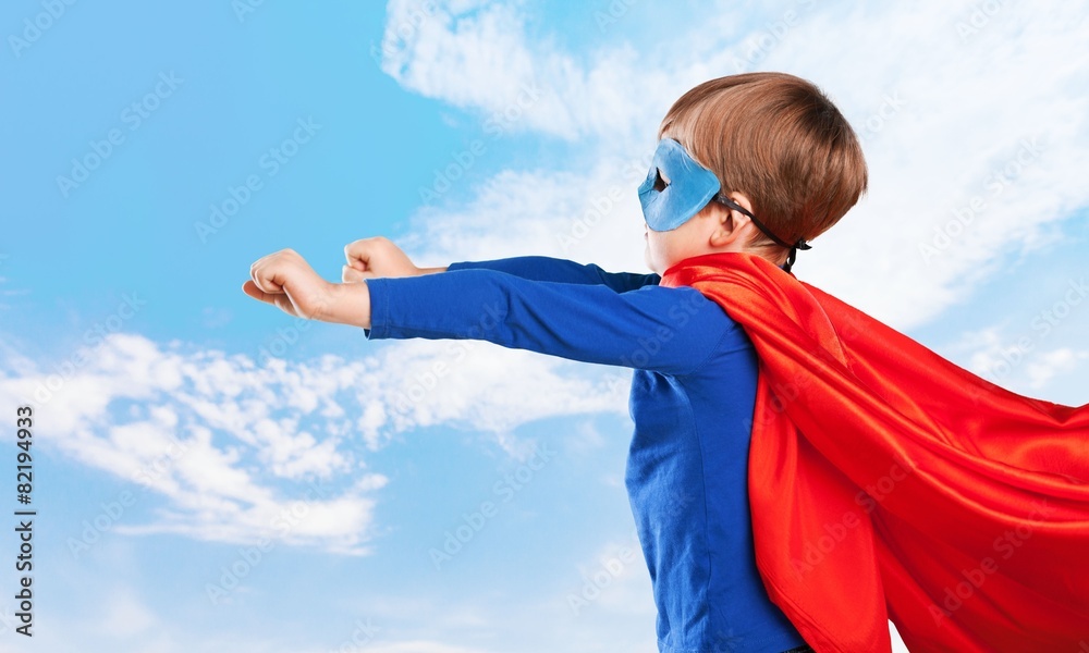 Kid. Superhero kid against blue sky background. Girl power