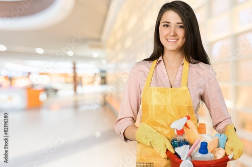 Cleaning. Young maid with bucketful looking at camera. photo