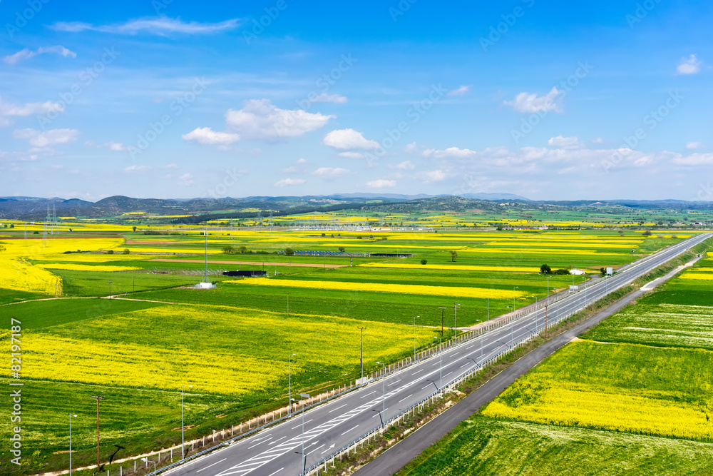 Fototapeta premium Aerial view of road passing through a rural landscape with bloom