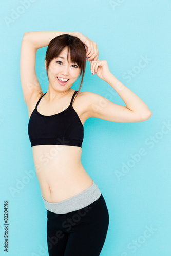 sporty asian woman on blue background © taka