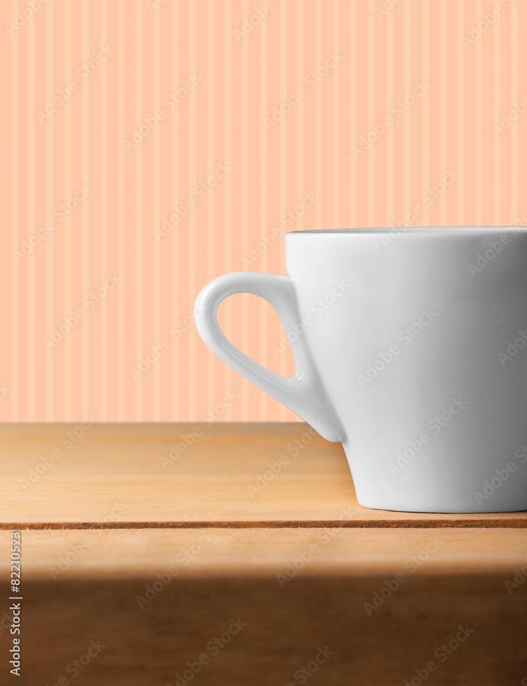 Design. Background with white cup on wooden table over grunge Design. Background with white cup on wooden table over grunge