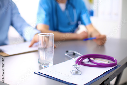 Two doctors discussing and working together in a medical office