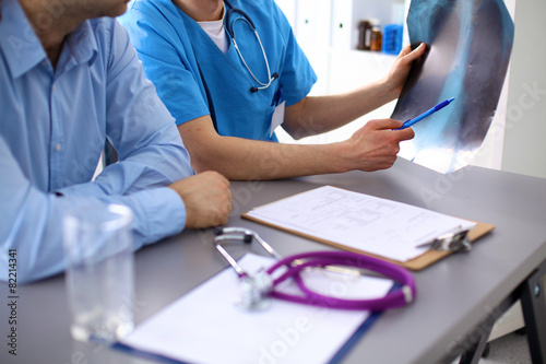 Two doctors discussing and working together in a medical office