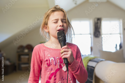 Caucasian girl singing karaoke at home