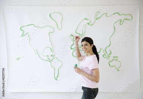 Mixed Race woman painting world map