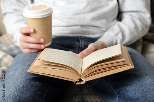 Young man reading book, close-up, on light background