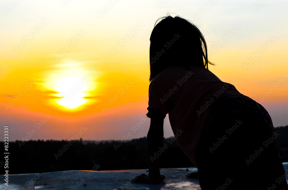 Fototapeta premium Girl standing on the top of building overlooking sunrise