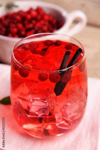 Compote with red currant in glassware on wooden table, closeup