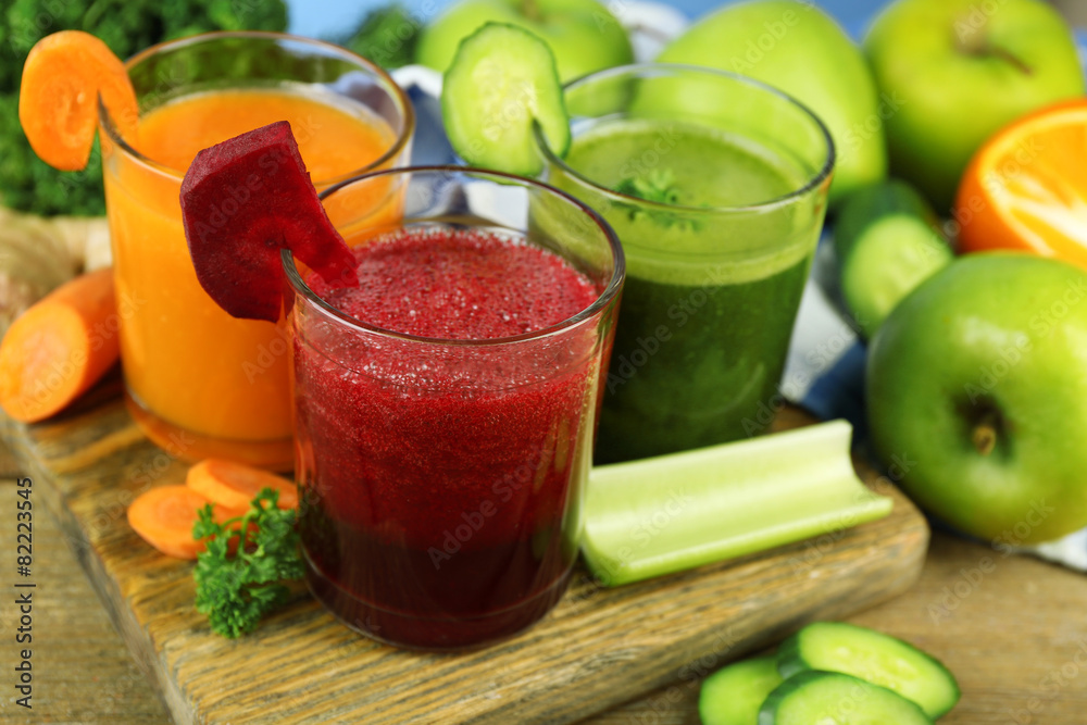 Assortment of healthy fresh juices on wooden table background Assortment of healthy fresh juices on wooden table background