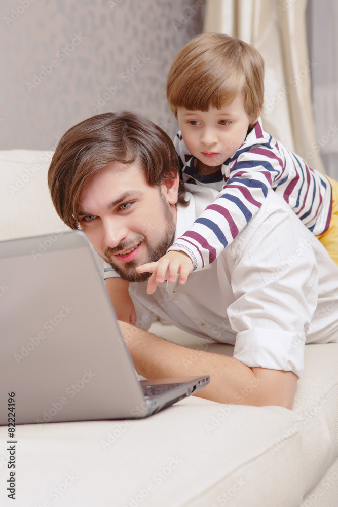 Man and boy use laptop Man and boy use laptop