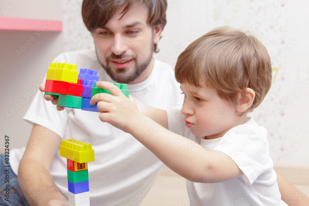 Father and son play with building kit Father and son play with building kit