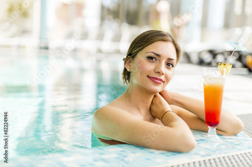 Beautiful woman in a pool with a cocktail