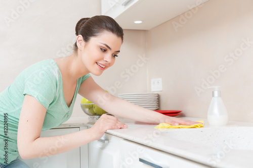 Beautiful young lady washing kitchen
