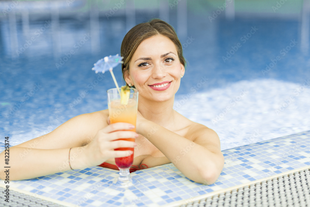 Beautiful woman in a pool with a cocktail Beautiful woman in a pool with a cocktail