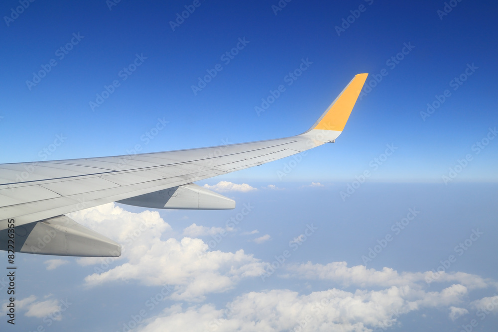 Wing of an airplane flying above sky Wing of an airplane flying above sky