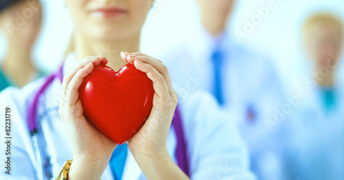 Female doctor with stethoscope holding heart photo