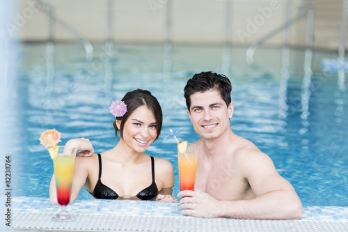 Couple drinking a cocktail by the swimming pool and relaxing © NDABCREATIVITY
