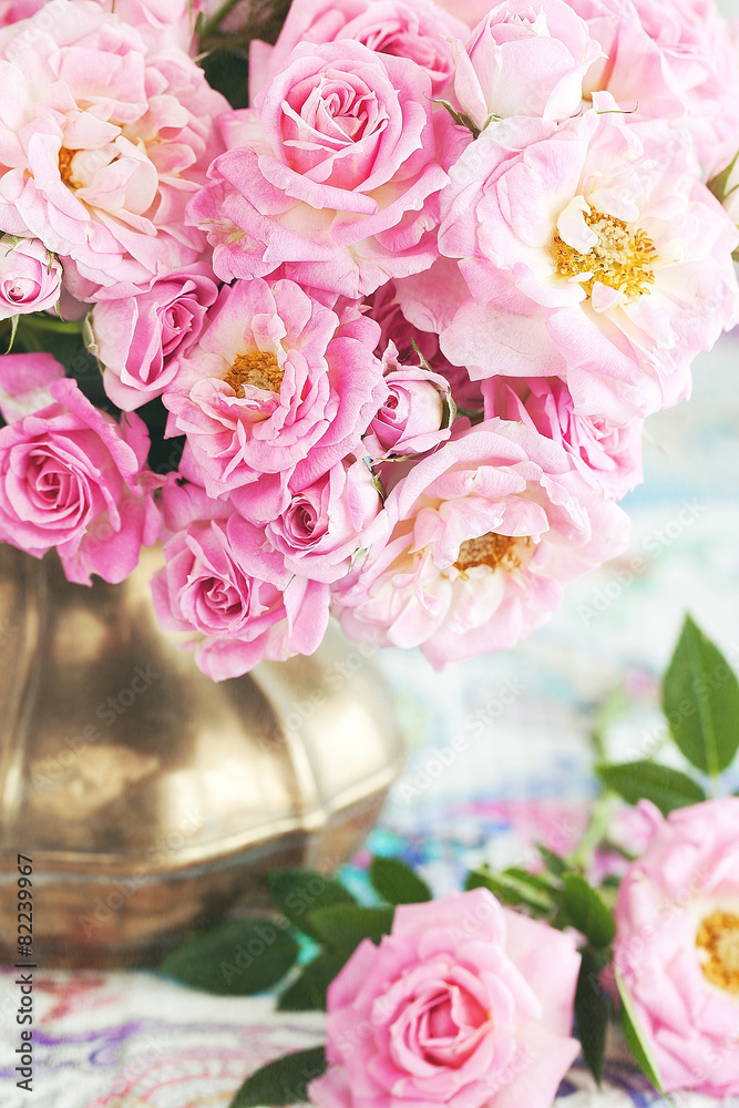 Floral composition with a pink  roses in a vintage jug .