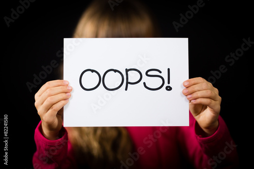 Child holding OOPS sign