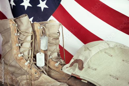 Old combat boots, dog tags, and helmet with American flag