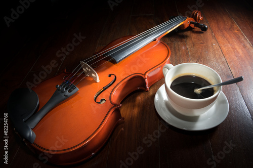 coffee cup with violin on wood surface.