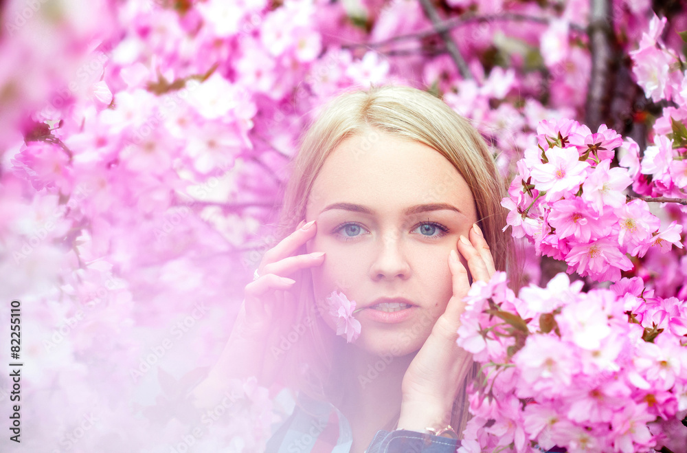 Cool young blonde with pink flower in mouth