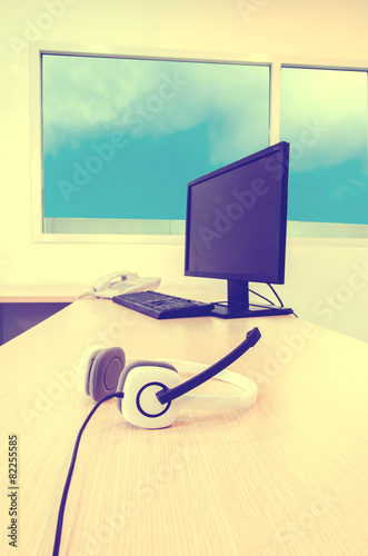 white headphone with computer set and telephone on wood table in photo