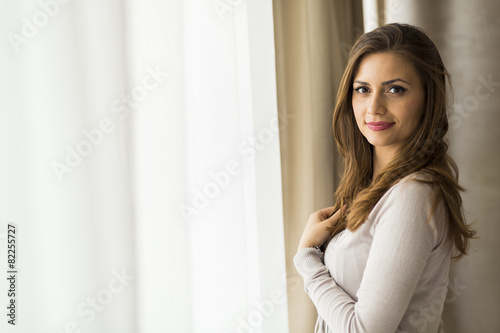 Beautiful and successful brunette posing in front of a window