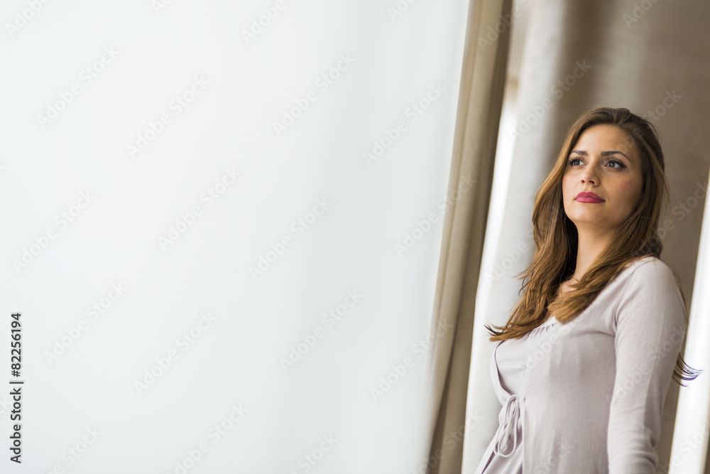 Beautiful and successful brunette posing in front of a window Beautiful and successful brunette posing in front of a window