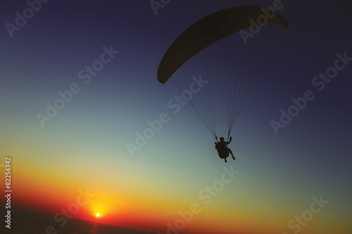 Paraglider silhouette against the background of the sunset sky