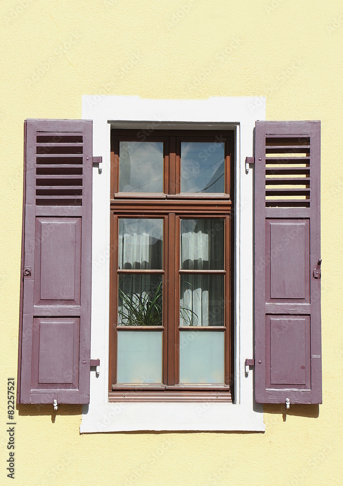 Gelbe Hauswand und Fenster mit lila Fensterläden – Stock-Foto | Adobe Stock