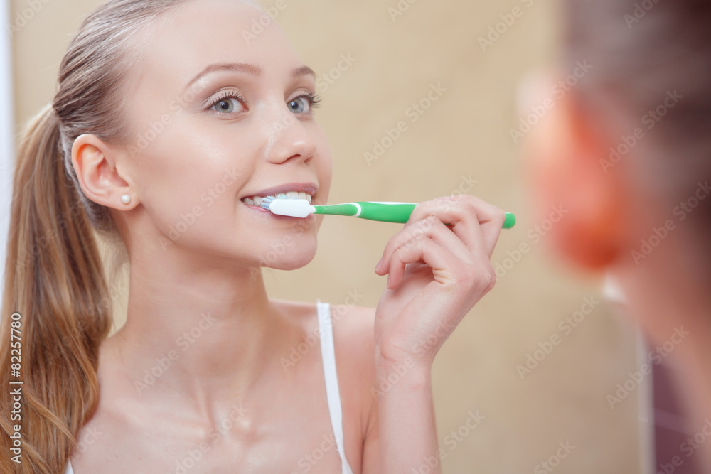 Pretty young woman cleaning her teeth Pretty young woman cleaning her teeth