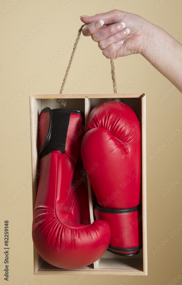 Pair of red boxing gloves in a wooden box