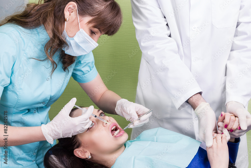 Dentist making anaesthetic injection to female patient Stock Photo