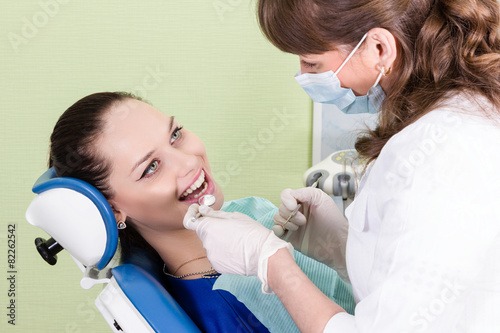 Dentist checks the teeth to his patient